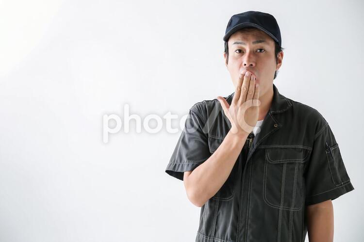 口をおさえる整備士 1人,30代,40代の写真素材