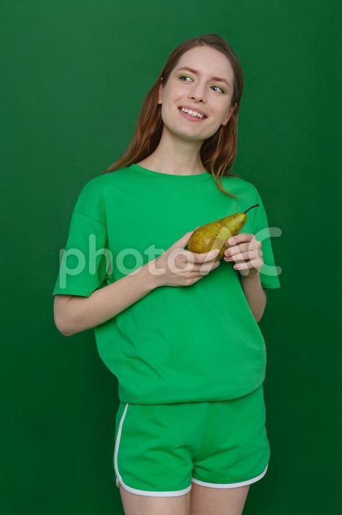 洋なしを持つ笑顔の女性 女性,洋なし,持つの写真素材