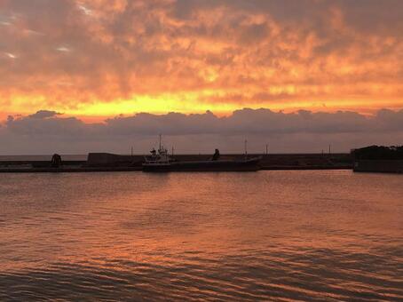 雲を照らす朝焼けと屋久島の港 屋久島,黄金色,反射の写真素材