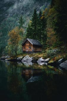 水面が鏡のように映し出す幻想的なキャビンの写真