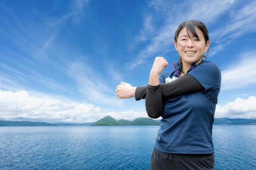 青空とストレッチする女性 女性,笑顔,スポーツウェアの写真素材