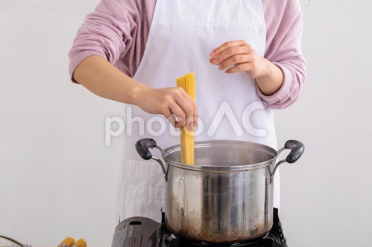 パスタを茹でる女性　Cooking パスタ,料理,エプロンの写真素材
