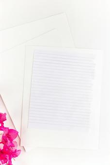 ノートの1ページと白い紙とピンクの花 ノートの1ページと白い紙とピンクの花の写真