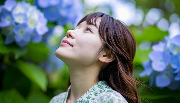 紫陽花の道で上を見上げる若い女性 紫陽花の道で上を見上げる若い女性の写真