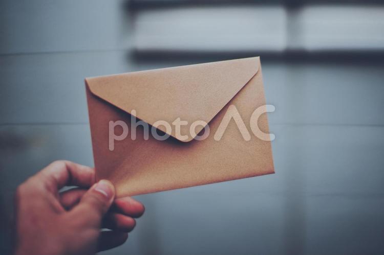 茶色の手紙を持つ人の手元 茶色の手紙を持つ人の手元 手紙,封筒,渡すの写真素材