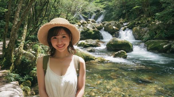 夏の渓流沿いの遊歩道に立つ若い日本人女性 夏の渓流沿いの遊歩道に立つ若い日本人女性の写真