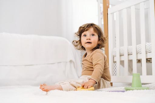玩具を握り見上げる子供 玩具を握り見上げる子供 赤ちゃん,かわいい,お座りの写真素材