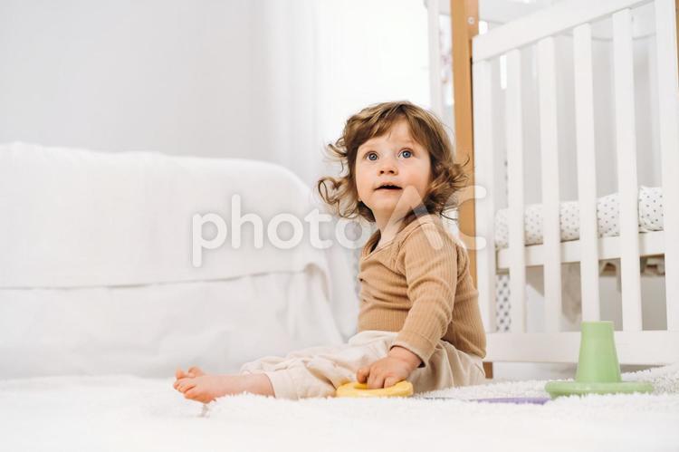 玩具を握り見上げる子供 赤ちゃん,かわいい,お座りの写真素材