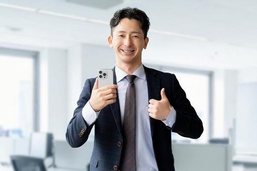 スマホを持っていいね！のポーズをする男性 男性,スマホ,笑顔の写真素材
