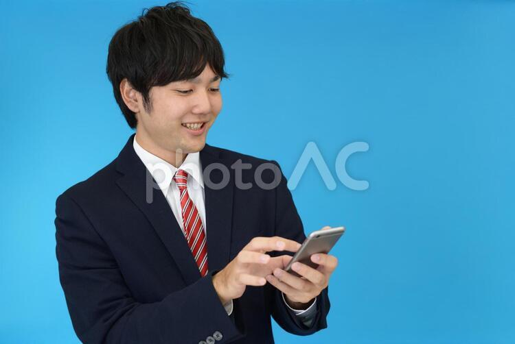 スマートフォンを持つ笑顔のビジネスマン 男性,ビジネスマン,男の写真素材