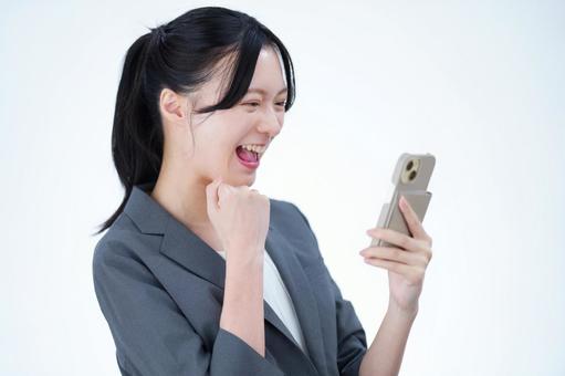 女性がスマートフォンを見て笑う 女性,スマートフォン,持つの写真素材