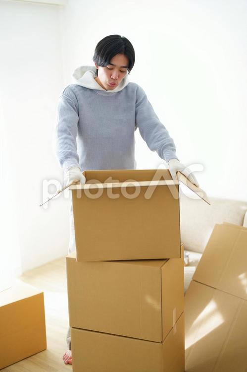 引っ越しの荷造りの段ボール箱と男性 引っ越し,一人暮らし,男性の写真素材
