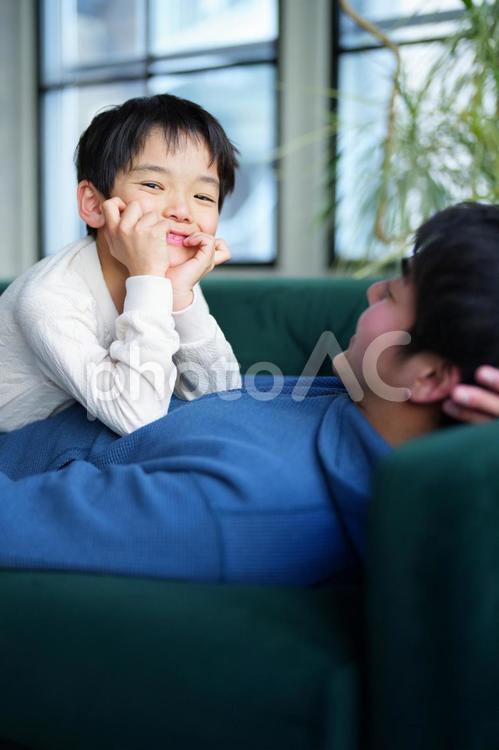 寝転んで頬杖をつく男の子 親子,男の子,小学生の写真素材