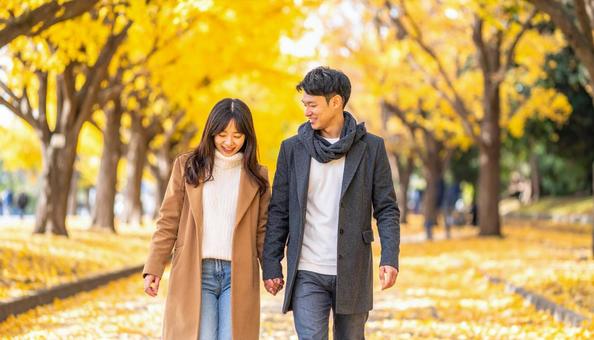 秋の紅葉を楽しんで公園を散歩するカップル 秋の紅葉を楽しんで公園を散歩するカップルの写真