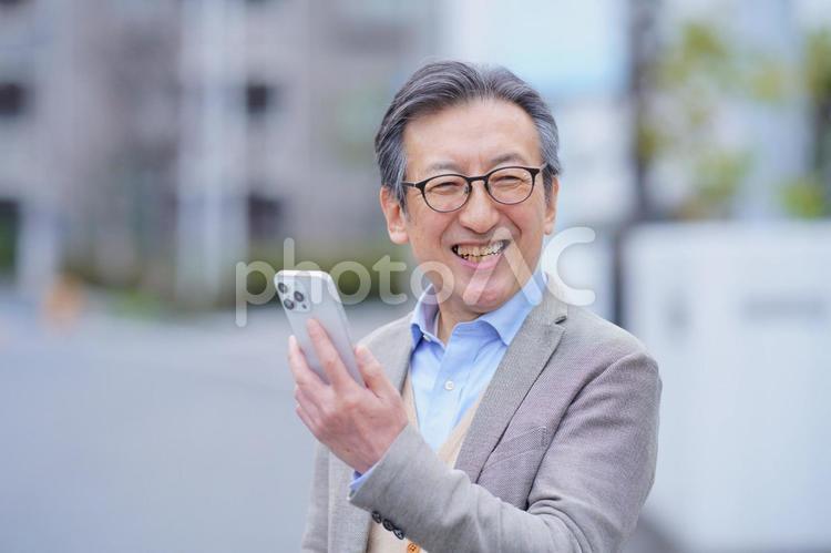 屋外でスマートフォンを使う笑顔のおじいちゃん 男性,おじいちゃん,1人の写真素材