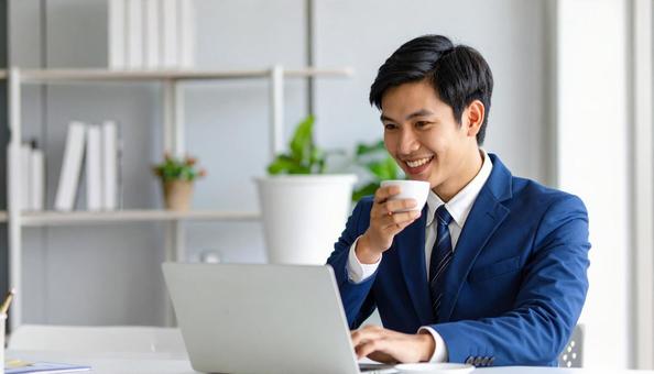 パソコンの前で休憩する笑顔のサラリーマン パソコンの前で休憩する笑顔のサラリーマンの写真