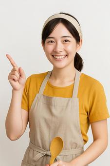 女性が笑顔で指を刺し紹介している風 女性が笑顔で指を刺し紹介している風の写真