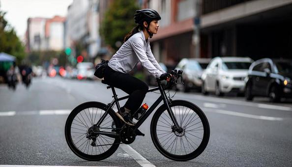 ロードバイクでサイクリングする女性の写真