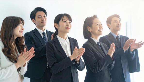 拍手で称え合うビジネスマンの写真