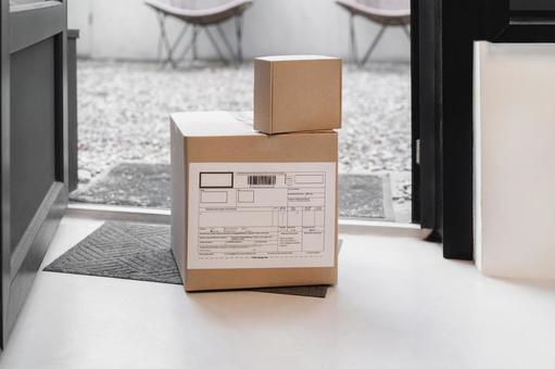 玄関に置かれた段ボール箱の荷物 配達,フードデリバリー,デリバリーの写真素材