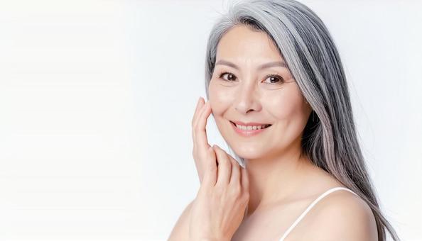 カメラ目線で頬を撫でるシニアの女性 カメラ目線で頬を撫でるシニアの女性の写真