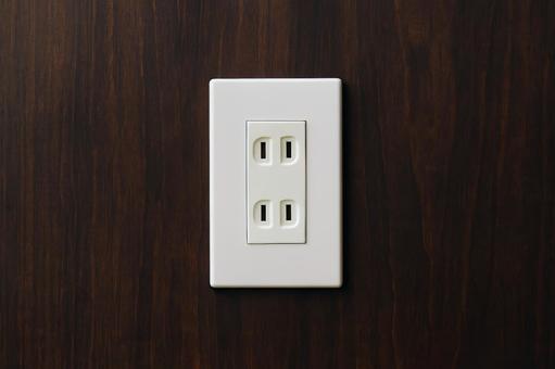 木目の壁と白い電源コンセント 木目の壁と白い電源コンセントの写真