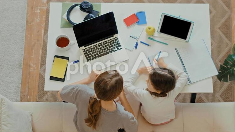 宿題をする女の子と話す女性 親子,女の子,女性の写真素材