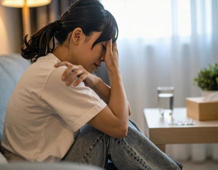 部屋でうつ病・体調不良に悩む日本人女性 部屋でうつ病・体調不良に悩む日本人女性の写真