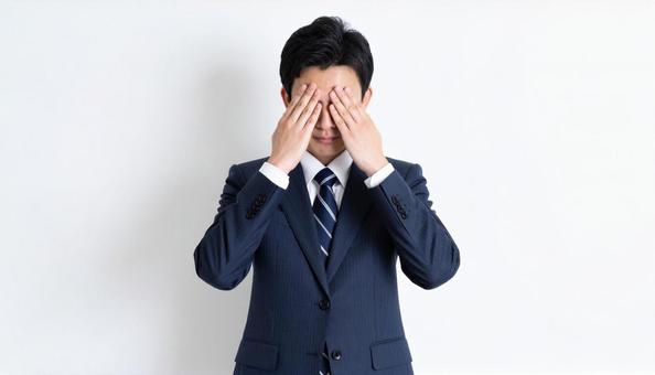 ストレスで顔をおおう日本人ビジネスマン ストレスで顔をおおう日本人ビジネスマンの写真