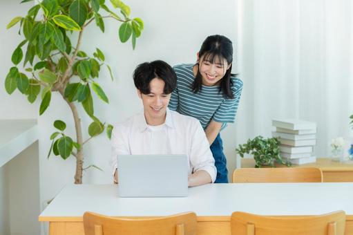 パソコンを見るカップル ノートパソコン,笑顔,カップルの写真素材