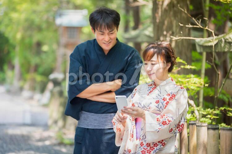 スマホを持つ浴衣姿の男女 浴衣,アプリ,カップルの写真素材
