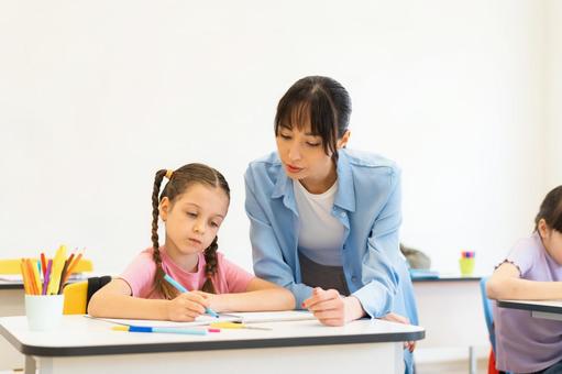 勉強する女の子を見守る女性 女性,女の子,子どもの写真素材