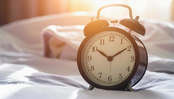 ベッドの上の目覚まし時計の写真
