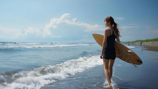 サーフボードをもって海を見つめる女性 サーフボードをもって海を見つめる女性の写真