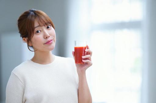 トマトジュースを持つカメラ目線の女性 女性,トマトジュース,赤の写真素材