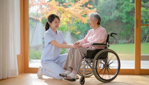 車椅子に乗った高齢女性と女性介護士 車椅子に乗った高齢女性と女性介護士の写真