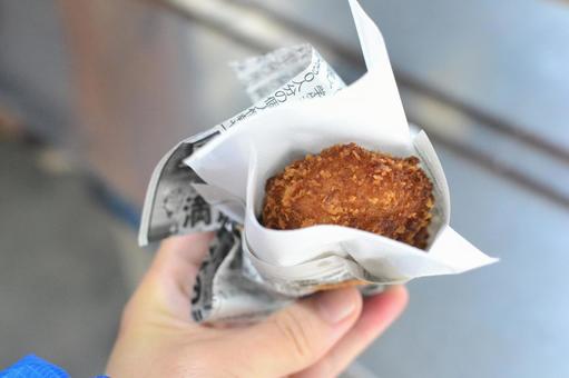 手に持った揚げたてコロッケ コロッケ,揚げ物,手に持つの写真素材