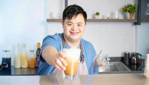 カフェで働くダウン症の男性の笑顔 カフェで働くダウン症の男性の笑顔の写真