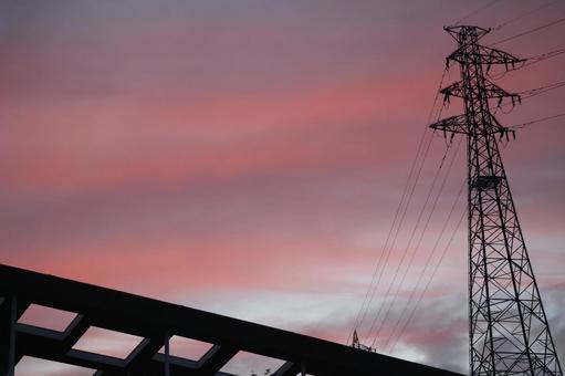 茜色の夕空と鉄塔と屋根の空の風景 茜色の夕空と鉄塔と屋根の空の風景の写真