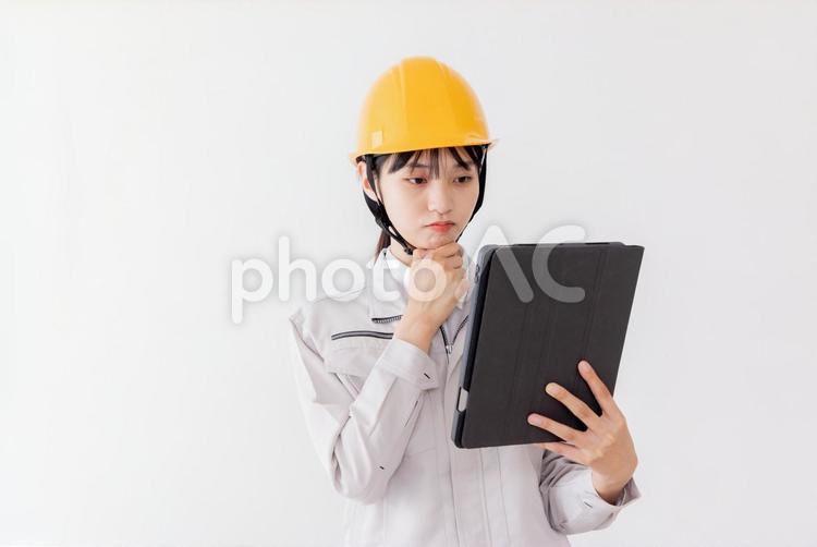 タブレットを使用する作業服の女性 女性,人物,日本人の写真素材
