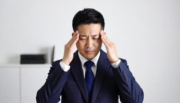 ストレスで顔をおおう日本人ビジネスマン ストレスで顔をおおう日本人ビジネスマンの写真