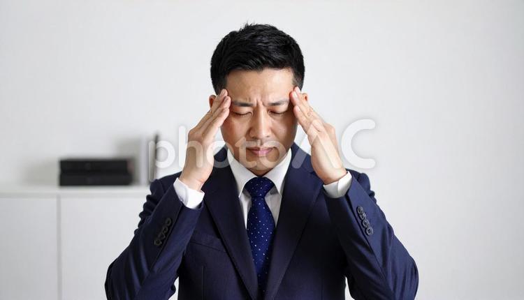 ストレスで顔をおおう日本人ビジネスマン ビジネスマン,サラリーマン,ストレスの写真素材
