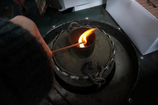 お寺のお焼香の火と線香を持つ手の写真