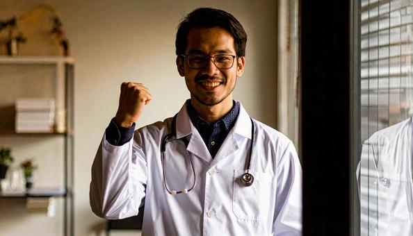 ガッツポーズをする日本人の男性医師 ガッツポーズをする日本人の男性医師の写真