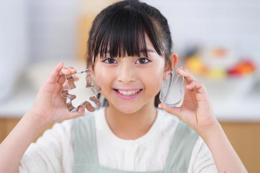 お菓子作りを楽しむエプロン姿の少女 女の子,日本人,型抜きの写真素材