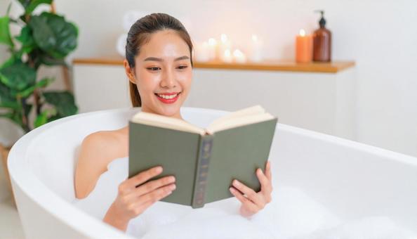 お風呂に浸かりながら読書を楽しむ女性 お風呂に浸かりながら読書を楽しむ女性の写真