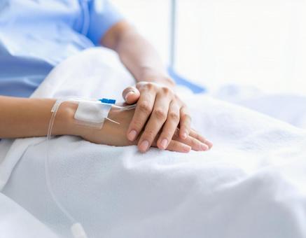 点滴治療を受ける患者の手元クローズアップ 点滴治療を受ける患者の手元クローズアップの写真