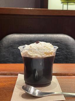 クリームの乗ったコーヒーゼリーとスプーン クリームの乗ったコーヒーゼリーとスプーンの写真