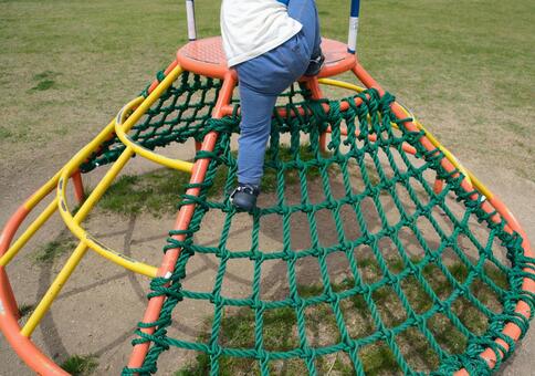 アスレチック遊具の頂上へ登る子供の後ろ姿 子供,公園,遊具の写真素材