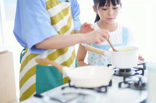 エプロン姿で調理を学ぶ女の子の写真